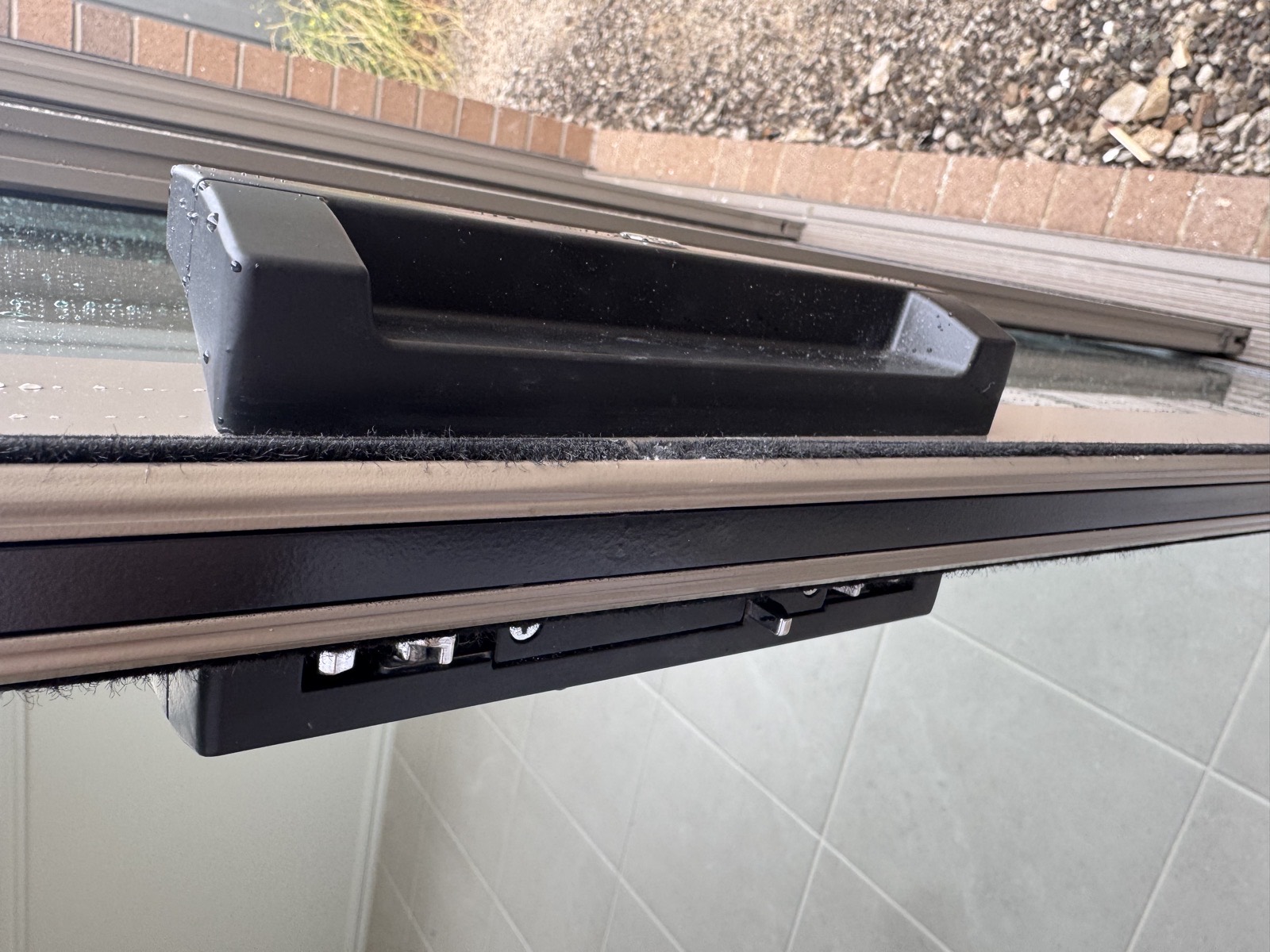 The same sliding door frame after repair, photographed in daylight, the aluminium straight and evenly finished around the lock keeper plate.