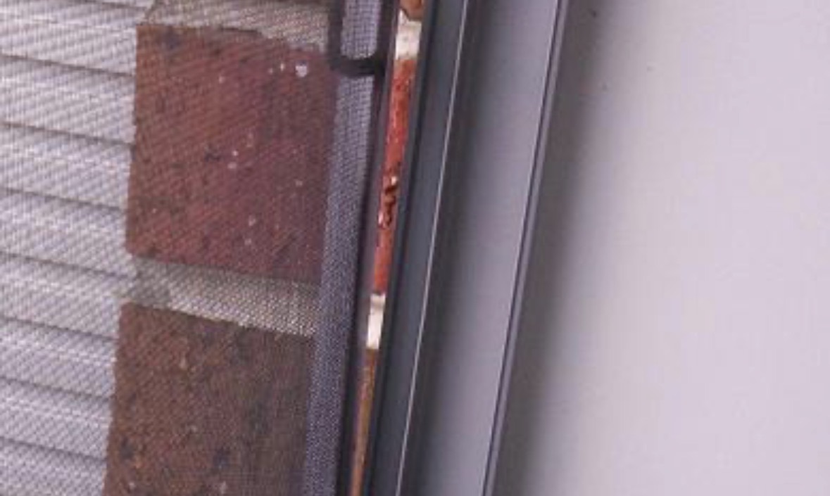 The same aluminium window frame after repair, the strip running straight beside the brickwork.